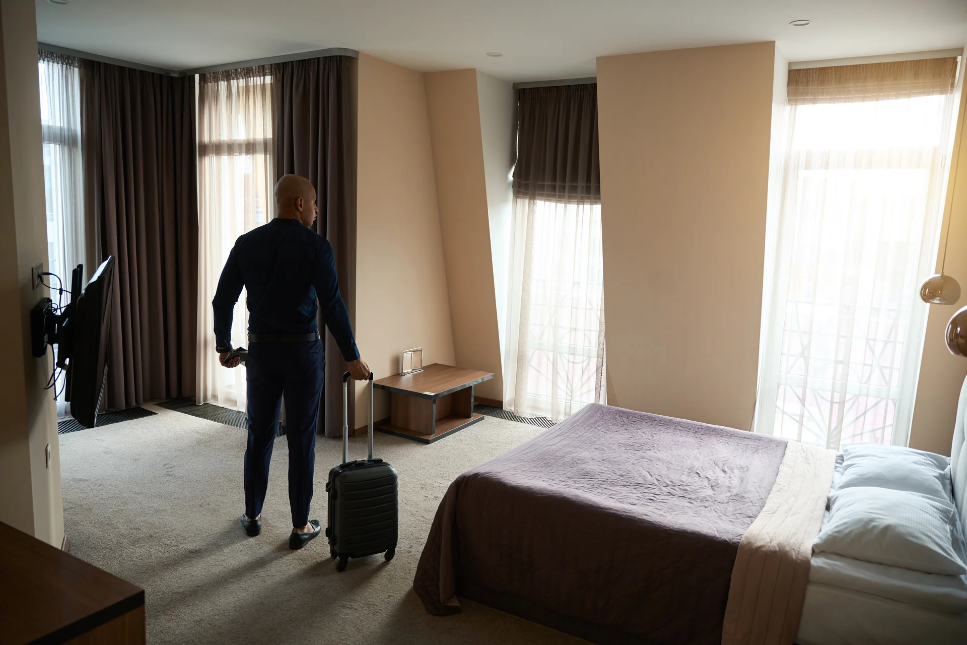 Hombre con maleta en habitación de hotel