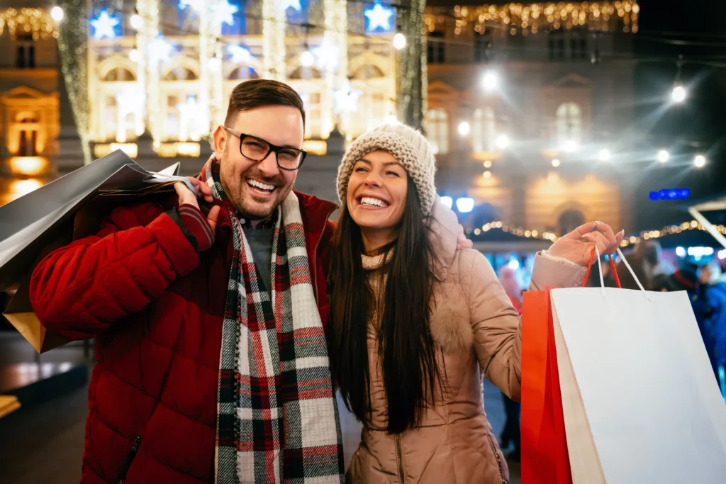 Retrato de una pareja feliz comprando en mercado navideño.